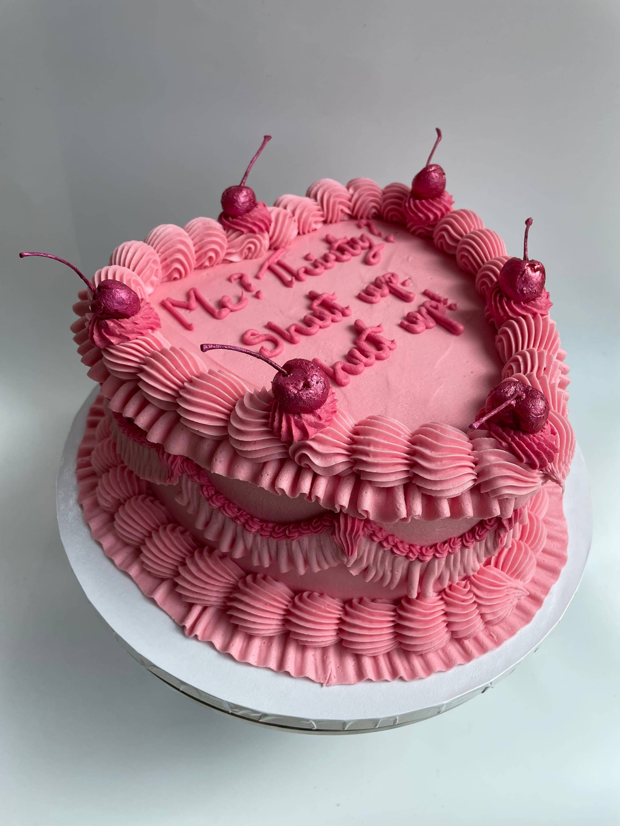 Two-tier heart-shaped 30th birthday cake in hot pink shell-piped buttercream with a playful iced message